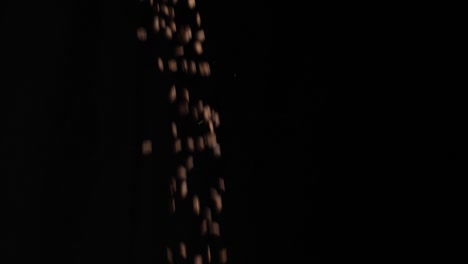 coffee beans falling with black background, slow motion
