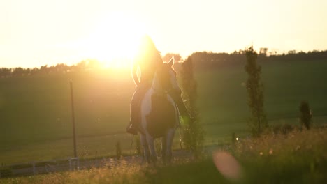 Cowgirl-Reitet-Auf-Einem-Pferd-Mit-Einem-Wunderschönen-Sonnenuntergang-Dahinter-In-Zeitlupe