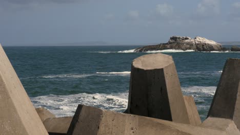 The-Atlantic-ocean-through-a-seawall-construction-with-an-island-in-view-PANNING