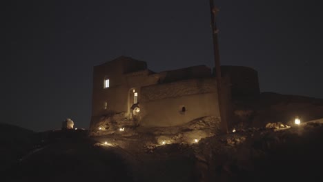 old house traditional local historical architecture design of a house in desert at night the stars blinking the oil lantern light top of the hill evening time astronomy travel for galaxy photography