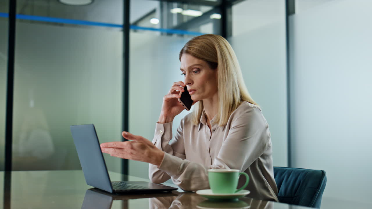 Primo piano di dirigente seria che telefona in ufficio. Affarista che parla al cellulare.