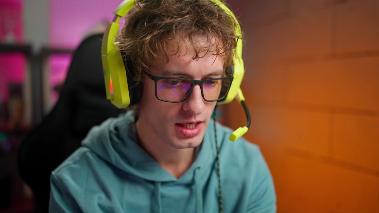 Focused Young Man Playing Mobile Game with Headset