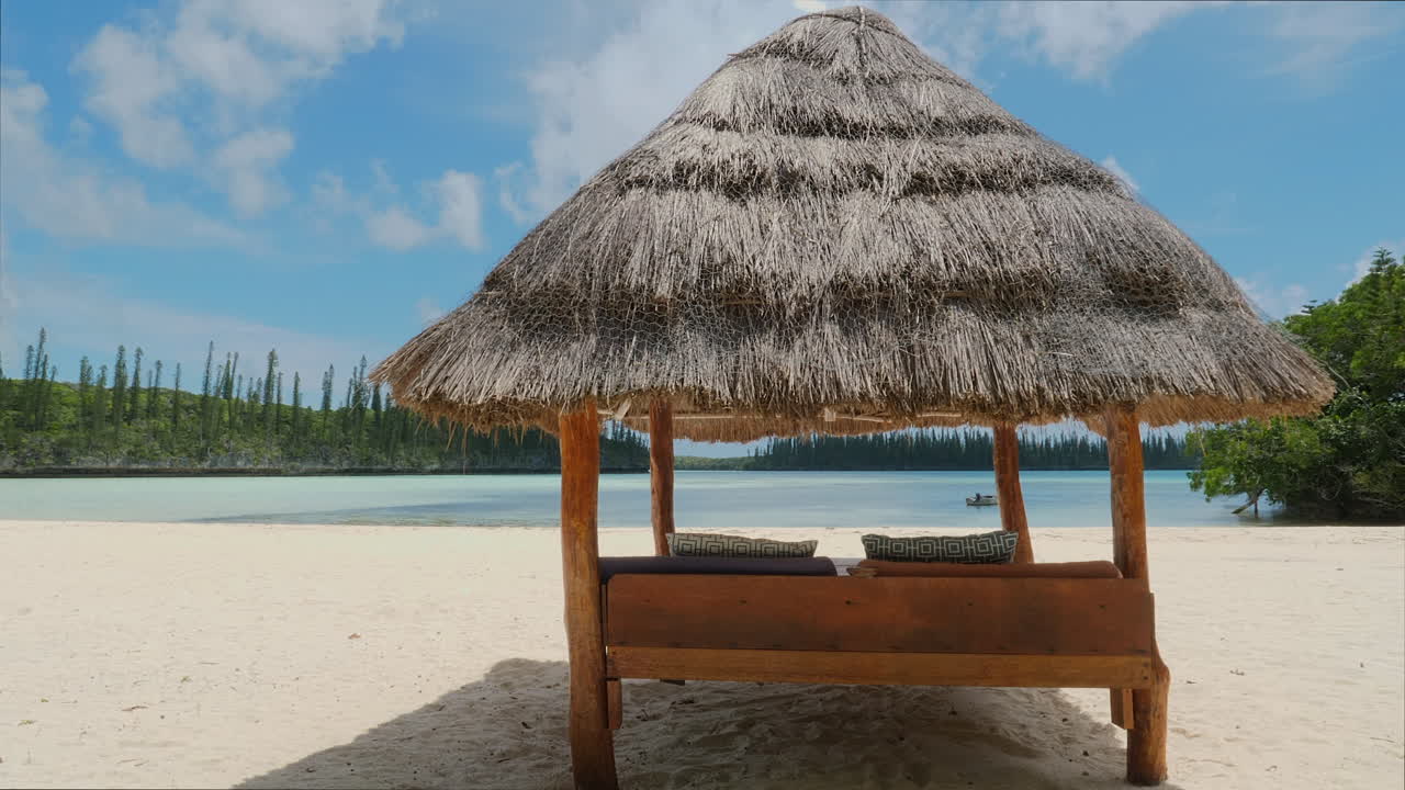tiro de seguimiento de la cabaña de playa con techo de paja en la playa tropical de arena blanca, isla de pinos