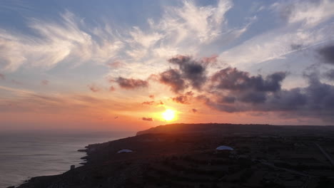 hyperlapse drone toma de una puesta de sol con nubes sobre la costa de la isla de malta