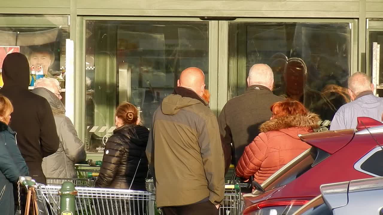 Cornona Covid virus shoppers crowd panic buying waiting at store doors UK retail