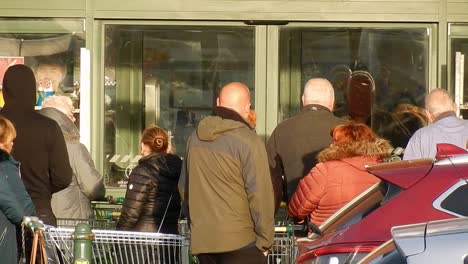 cornona covid virus shoppers crowd panic buying waiting at store doors uk retail