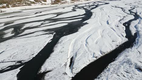 Malerischer-Fluss-In-Der-Verschneiten-Isländischen-Landschaft,-Luftaufnahme-Von-Oben
