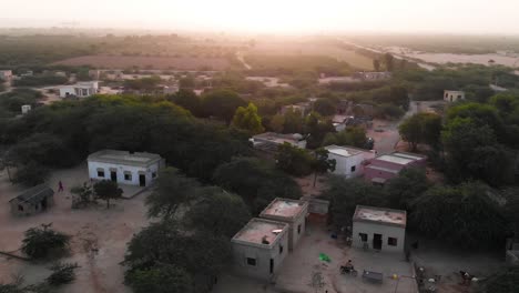 aerial parallax shot view of rural village in sindh with sunset on horizon