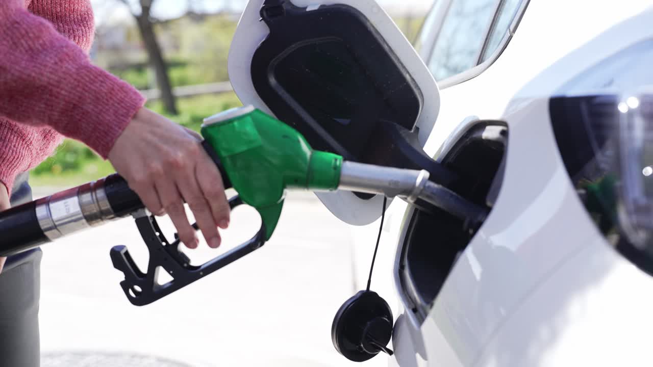 Close-up of Hand Refueling White Car at Gas Station