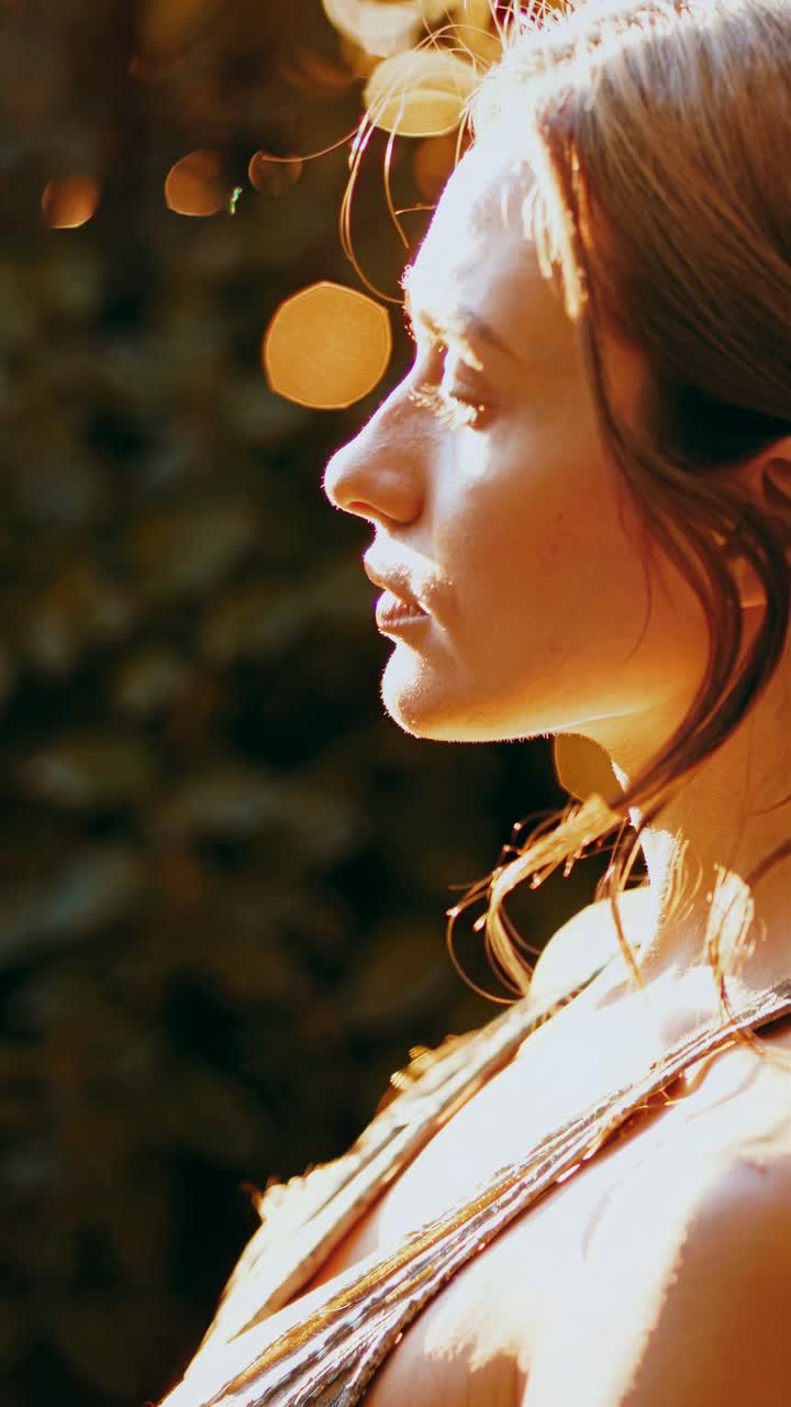 Profile view of a woman in warm sunlight, capturing a serene moment