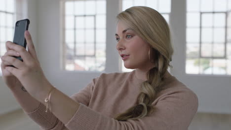 Porträt-Einer-Lächelnden-Jungen-Blonden-Frau,-Die-Mit-Smartphone-Kamera-Technologie-Ein-Selfie-Foto-Macht-Und-Sich-Einen-Neuen-Apartment-Lifestyle-Teilt