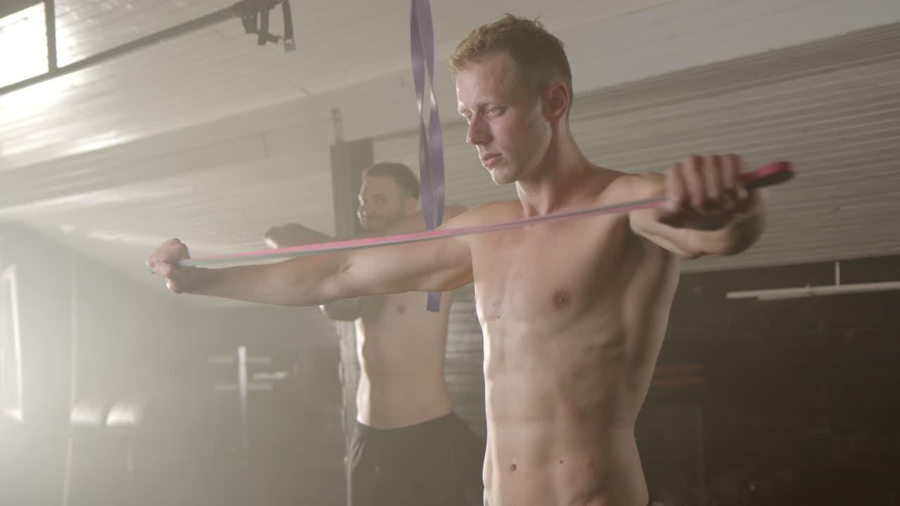 Men exercising in the gym with resistance bands