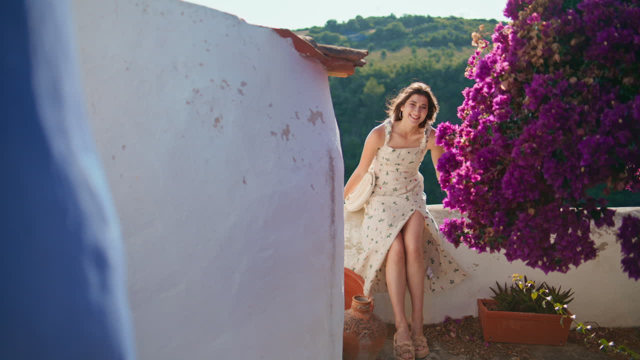 sensual morena posando vista general balcón rayos de sol pueblo. mujer mirando cámara