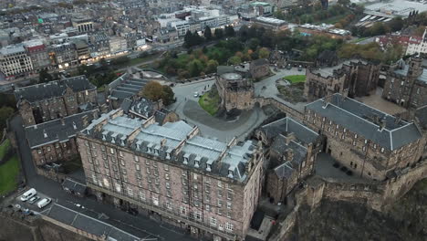 an impressive drone shot looking down on edinburgh castle and panning up to see arthur's seat in the distance at sunset