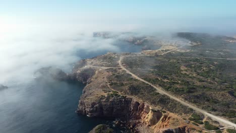 Retiro-Aéreo-De-La-Pintoresca-Costa-Rocosa-Envuelta-En-Niebla,-Sureste-De-Portugal