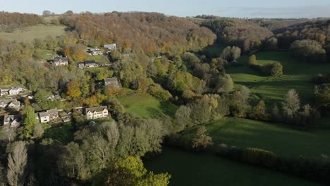 UK-Autumn-Wooded-Valley-Village-Aerial-Cotswolds-Sheepscombe-Gloucestershire-Trees-Landscape-Countryside