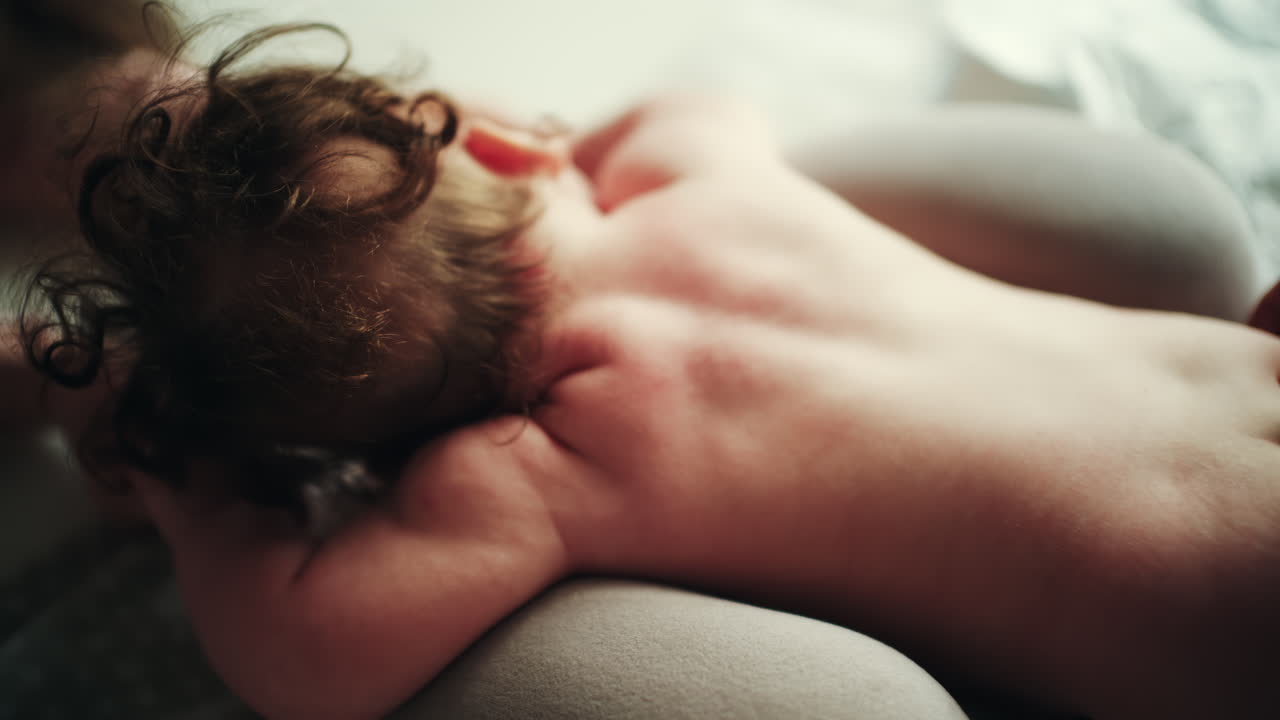 Infant lying on stomach while caregiver gently massages baby's back during wellness routine