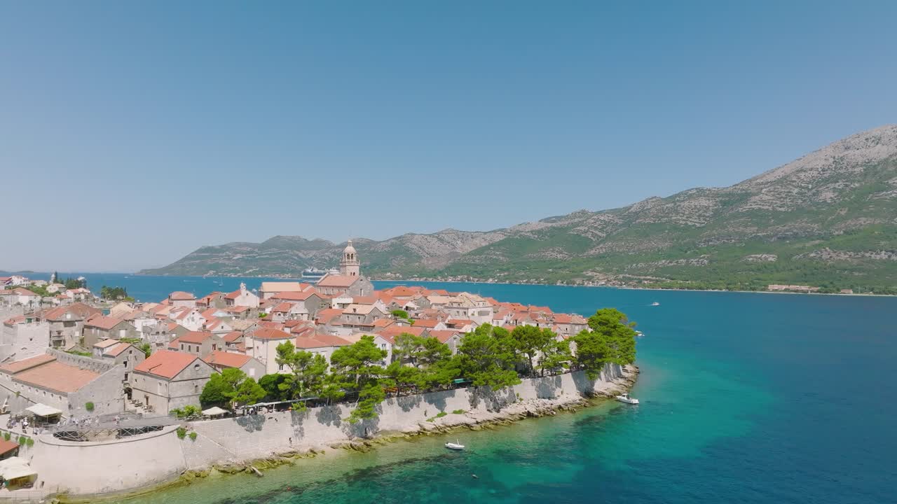 아드리아 해의 푸른 크리스탈 물과 크로아티아의 울창한 초록 숲으로 둘러싸인 코르라 섬의 집들의 그림 같은 풍경