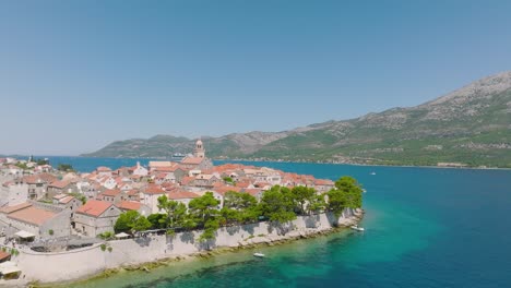 picturesque landscape of houses on korcula island surrounded by blue crystal water of adriatic and lush greenery forest in croatia