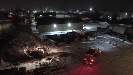 snowplows working at night, drone view in orford, québec, canada