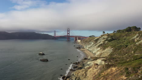 rocky mountain with golden gate bridge in the background in san francisco, united states. aerial drone shot