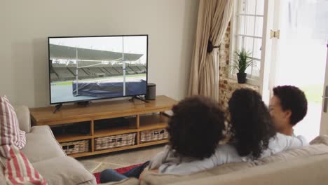 Zusammenstellung-Einer-Glücklichen-Familie,-Die-Zusammen-Zu-Hause-Sitzt-Und-Hochsprung-Leichtathletik-Im-Fernsehen-Verfolgt