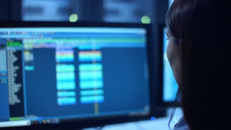 woman monitoring screens at night