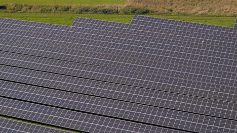 Teleobjektiv-Fliegt-über-Ein-Riesiges-Solarkraftwerk-Mit-Mehreren-Solarpaneelen-Auf-Einem-Grünen-Hügel-In-Deutschland,-Erneuerbare-Energien,-Luftaufnahmen
