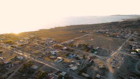 Panorámica-Sobre-La-Ciudad-Costera-Del-Desierto-Al-Atardecer-Con-Una-Luz-Dorada-Acariciando-Las-Casas