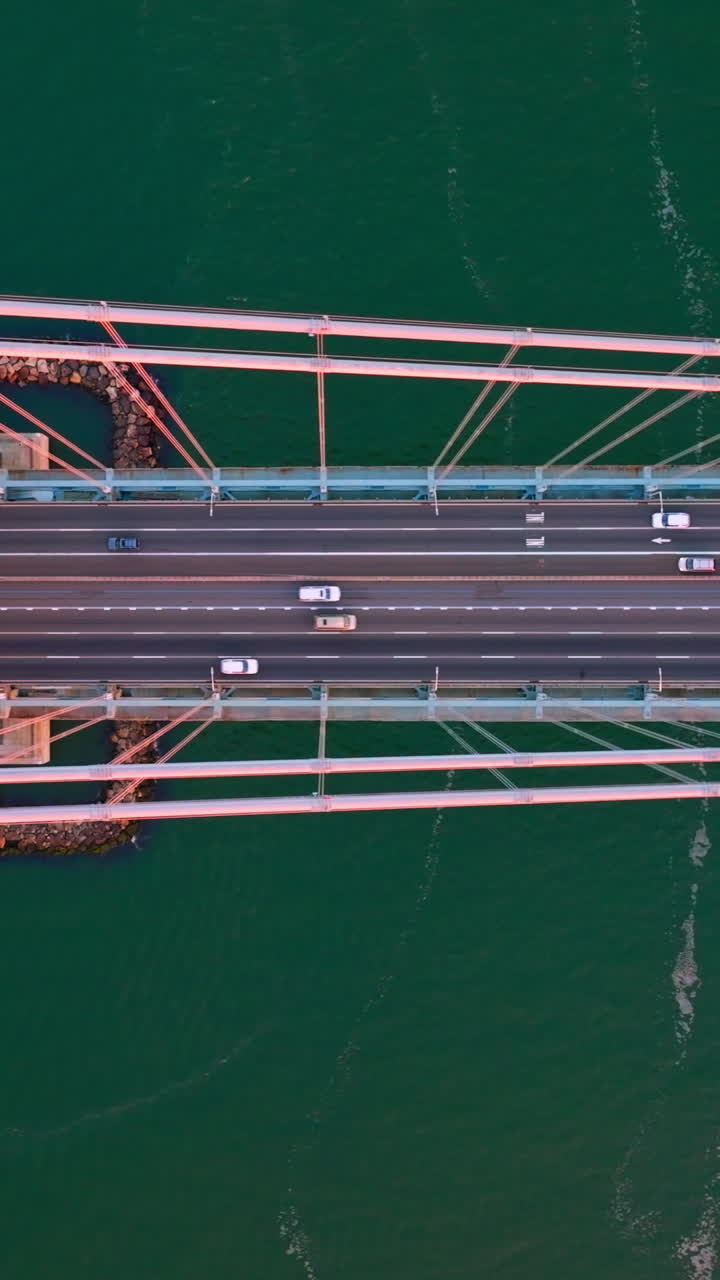 Flyover huge impressive bridge with fast moving cars. Bridge construction at the backdrop of sea-green river. Vertical video