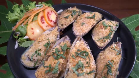 장식된 사이드 샐러드를 곁들인 회전판에 있는 맛있는 홍합