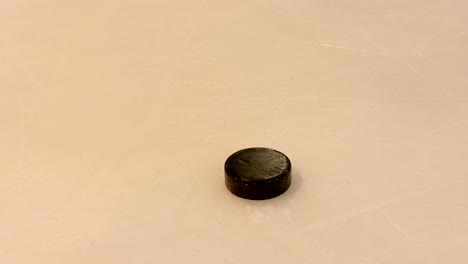 hockey stick hits the puck on the ice surface of the hockey stadium