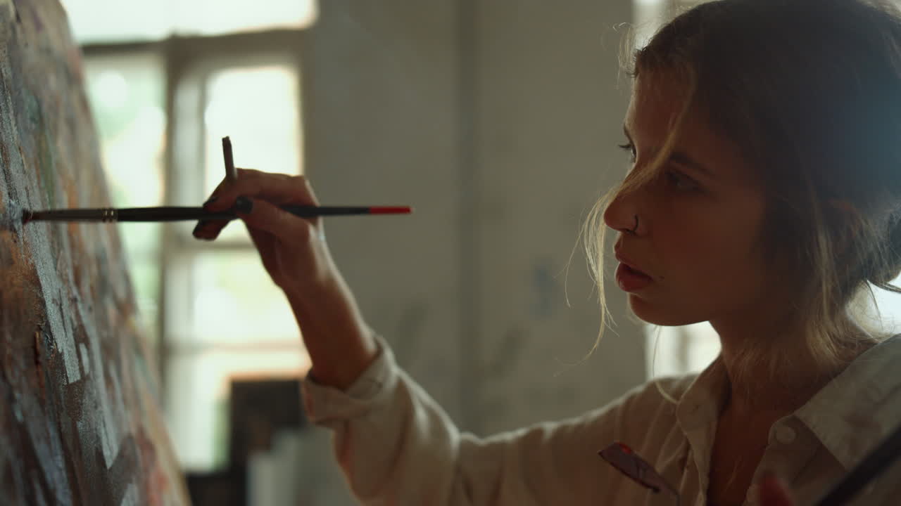 창의적인 화가가 스튜디오에서 예술 작품을 만들고 영감을 받은 소녀가 브러시 스트로크를 만 ⁇ 니다.