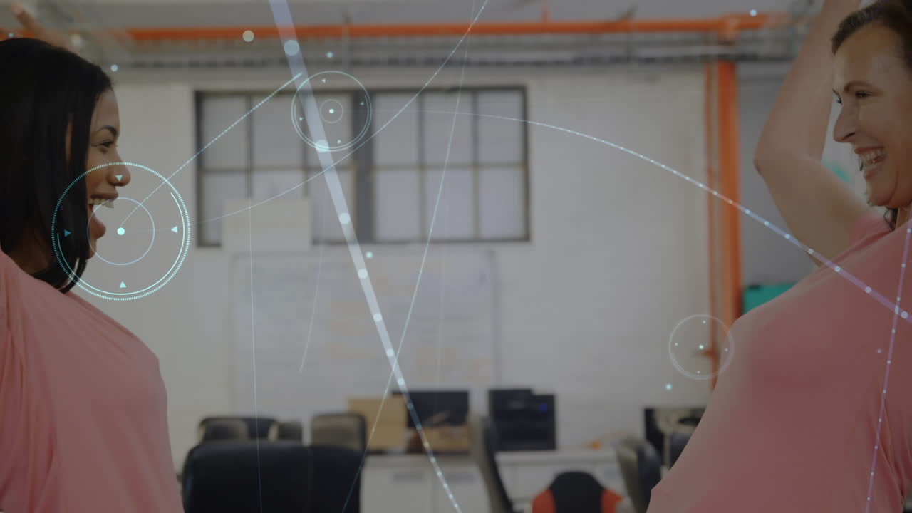 animación de una red brillante de conexiones contra dos mujeres diversas abrazándose en la oficina