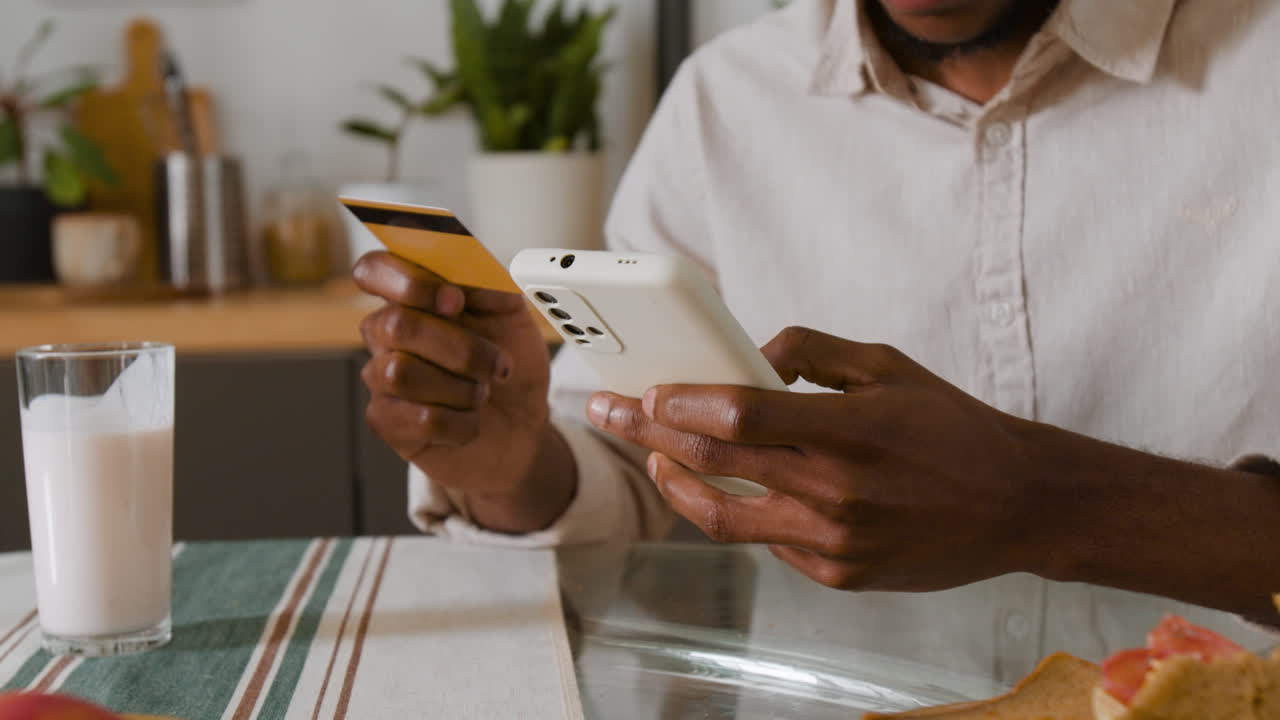 Person using phone and credit card for online payment