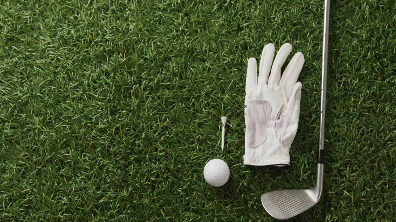 Close-up de taco de golfe, bola e luva na grama, espaço para texto, em câmera lenta