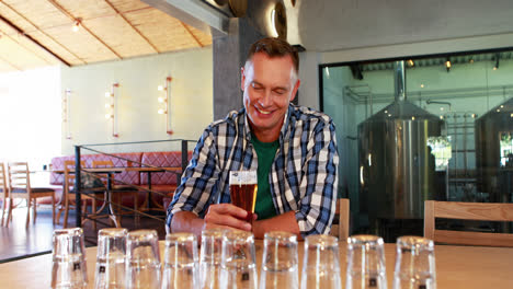 smiling man having glass of beer at counter 4k