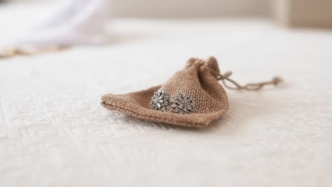 elegant jewelry in burlap pouch on lace