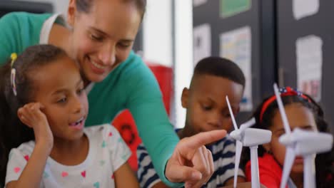 Front-view-of-Caucasian-female-teacher-teaching-student-about-windmill-in-the-classroom-4k