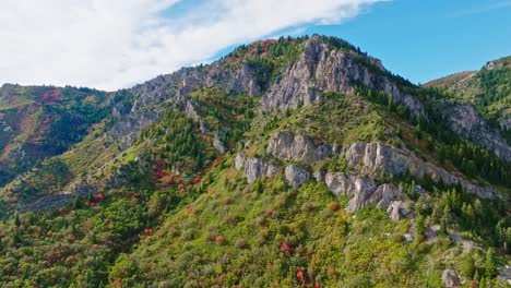 Flying-backwards-revealing-massive-Ogden-Utah-Canyon-mountains-with-beautiful-fall-colors-and-sky