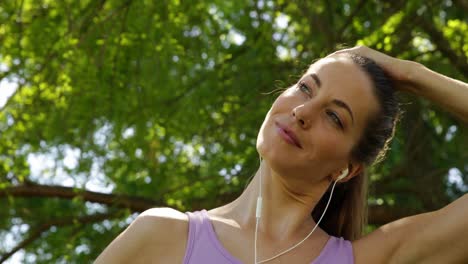 corredor estirando el cuello escuchando música en el parque
