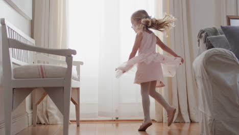 beautiful little girl dancing playfully pretending to be ballerina happy child having fun playing dress up wearing ballet costume with fairy wings at home 4k