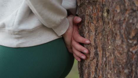 woman leaning against a tree in the forest