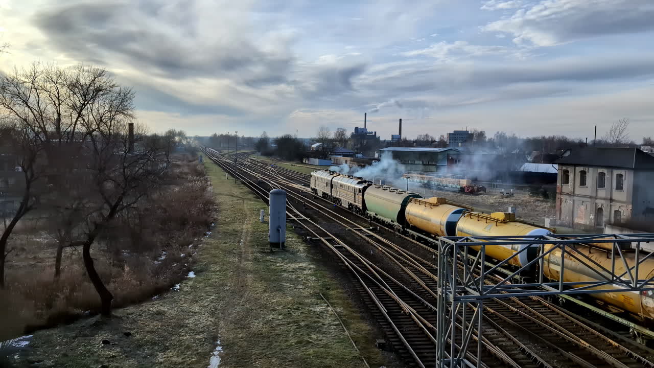 담배 를 피우는 디젤 기관차 가 크 마차 의 긴 줄 을 끌고 가면서 천천히 멀어지고 있다