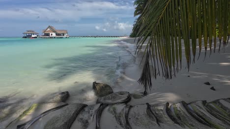 Shot-of-Beach-at-the-Kooddoo-Resort-in-the-maldives,-Showing-clear-water-lapping-on-a-sandy-beach