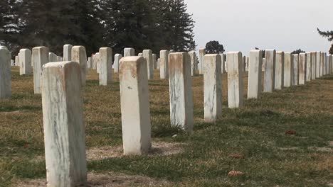 a striking rear view of headstones at arlington national cemetery as camera pans row after row of these memorials to fallen soldiers