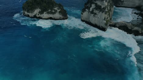 El-Dron-De-Vista-Aérea-Vuela-Sobre-Promontorios-Increíblemente-Hermosos-Con-Vegetación-En-La-Playa-De-Diamantes-Bañada-Por-Olas-Turquesas-Azules-En-Un-Día-Caluroso-Y-Soleado