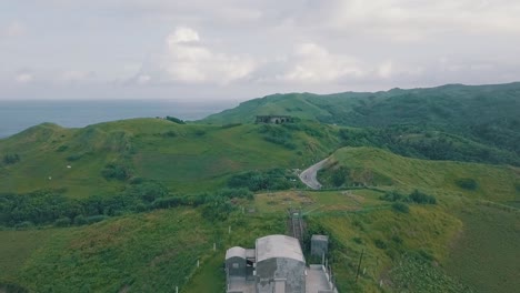 cinematic aerial drone view of a picturesque landscape of ocean meeting mountains in batanes, philippines