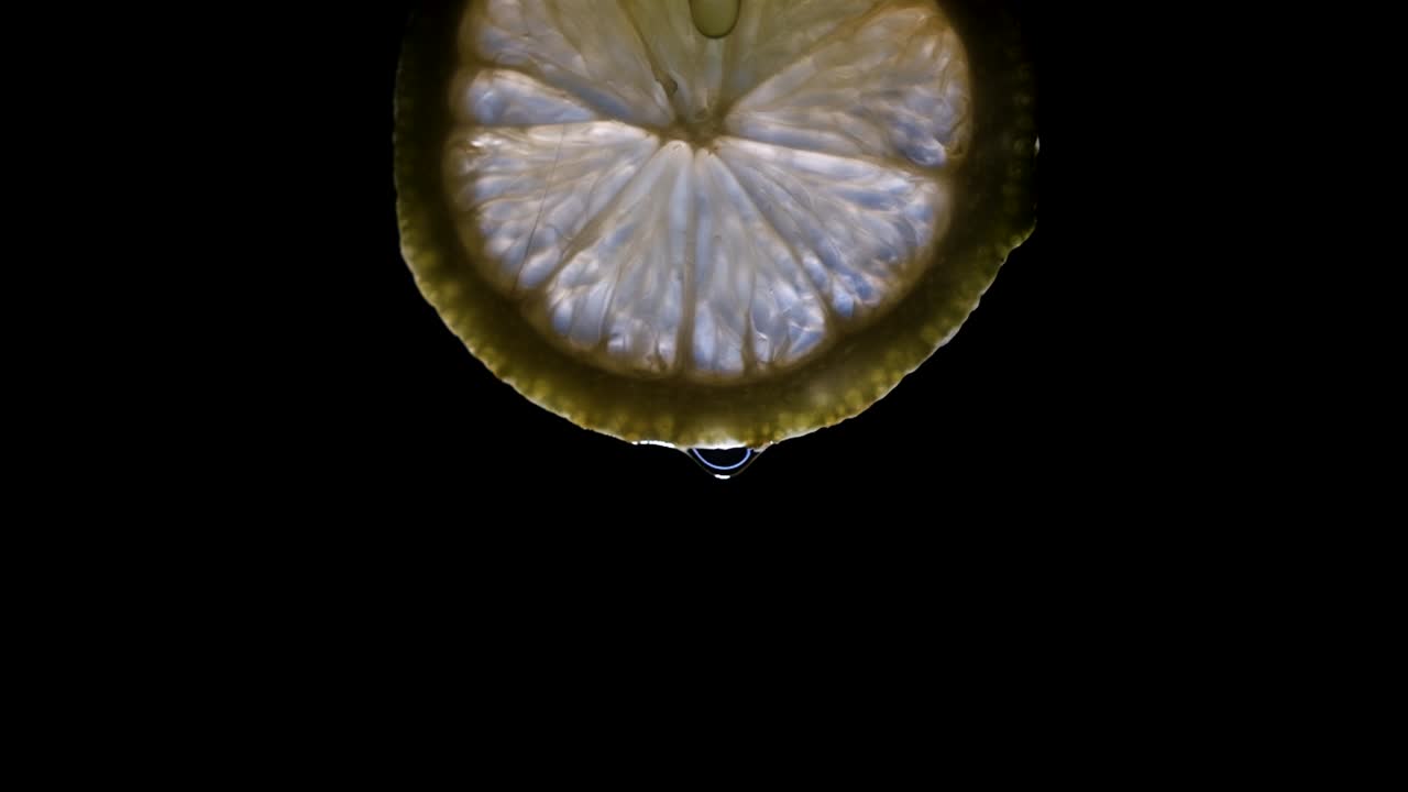 깜박이는 빛이 검정색 배경에 분리된 레몬 조각을 비춥니다