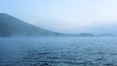 misty river with mountain in the background